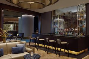 雅加达The Ritz-Carlton Jakarta, Pacific Place的一间酒吧,里面配有沙发和椅子