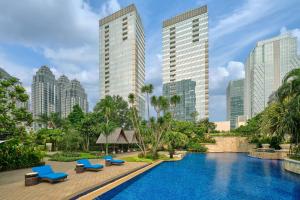 雅加达The Ritz-Carlton Jakarta, Pacific Place的一座高楼城市的游泳池