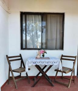 阿加斯杜尔斯Cabañas Virazon Aguas Dulces的一张桌子和两把椅子坐在窗边