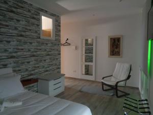 奥德赛克斯AL-Odeceixe Verde的卧室设有砖墙、一张床和一把椅子