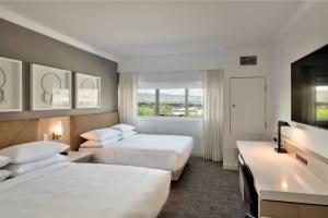坎卢普斯Delta Hotels by Marriott Kamloops的酒店客房设有两张床和窗户。
