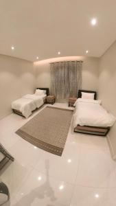 艾卜哈نزل ليلى الفندقية الفاخرة luxury的一间卧室设有两张床和窗户。