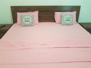 MatouryRESIDENCE VERO的一张带粉红色和灰色枕头的床