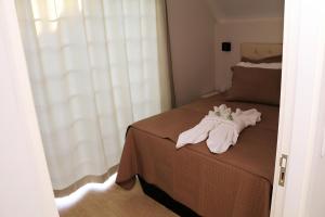 马塞利努拉穆斯POUSADA GERMÂNICA的一间卧室配有带毛巾的床