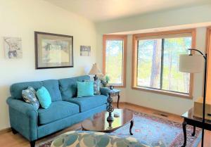 普雷斯科特Mountain Cabin Retreat in the Pines的客厅配有蓝色的沙发和桌子