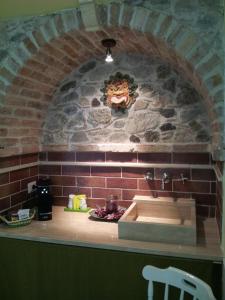 希拉Olimpo Palace Affittacamere的一个带水槽和石墙的厨房台面