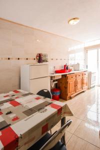 阿雷西费Ensuite Apartment A con Zona de Patio的厨房配有桌子和白色冰箱。