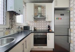 巴塞罗那Stay U-nique Apartments Calabria的厨房配有白色橱柜和不锈钢冰箱