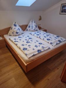 巴特霍夫加施泰因Landhaus Salzmann的一张带蓝色和白色棉被和枕头的床