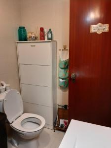 阿尔马达Almadense的浴室设有白色卫生间和红色门。
