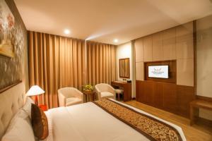 Bắc Giang北江孟青大酒店的配有一张床和一台平面电视的酒店客房