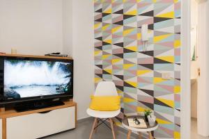 大加那利岛拉斯帕尔马斯Cosy flat in the beach的客厅配有电视和色彩缤纷的墙壁