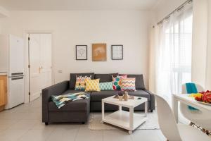 大加那利岛拉斯帕尔马斯Cosy flat in the beach的客厅配有沙发和桌子