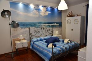 努奥罗B&B LE DUE ISOLE的一间卧室配有一张带海洋绘画的床