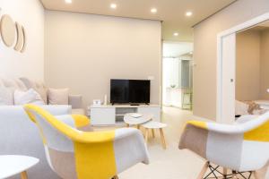 巴利亚多利德Apartamento DENVER - Centro, Nuevo, Diseño, Wifi的客厅配有黄色椅子和电视