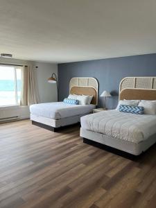 林肯市Seagull Beachfront Inn的一间卧室设有两张床和蓝色的墙壁