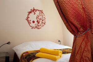 巴黎52 Clichy Bed & Breakfast - Chambre d'hôtes的一间卧室配有一张黄色毛巾的床