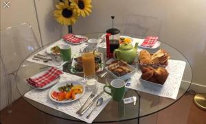巴黎52 Clichy Bed & Breakfast - Chambre d'hôtes的一张玻璃桌,上面放着食物