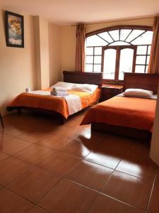 巴尼奥斯Hostal Viajero's的一间卧室设有两张床和窗户。
