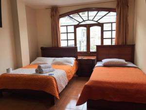 巴尼奥斯Hostal Viajero's的一间卧室设有两张床和窗户。