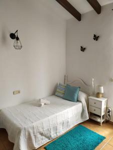 米哈斯Casa rural La Matriche的白色卧室配有床和蓝色地毯
