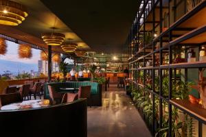 麦德林Blues Suites Medellín的一间设有桌椅的餐厅,种植了植物