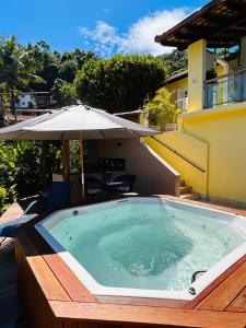 安格拉杜斯雷斯Casa Amarela的庭院内一个带遮阳伞的游泳池