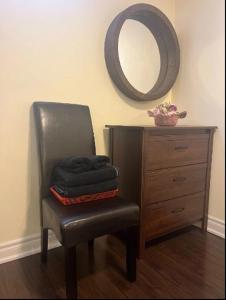 米西索加Cozy & Spacious Suite with Private Bathroom near Toronto Airport !的一张带镜子和梳妆台的黑椅