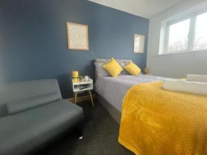 伯明翰Stylish 2 bed apartment.的蓝色卧室,配有床和椅子