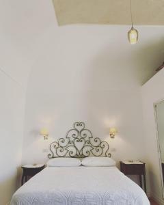 卡普里La Baia di Napoli的卧室配有白色床和银色床头板