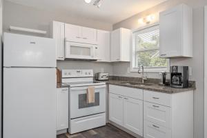 斩魔山Beach Twin B KDH123B的厨房配有白色橱柜和白色冰箱。