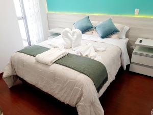 利马Hermoso apartamento Unidos En Familia en JESÚS MARÍA的一间卧室配有带白色床单和蓝色枕头的床。