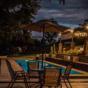 塔里哈Casa de Campo La Montaña的游泳池旁配有遮阳伞的桌椅