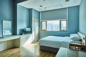 首尔Provista Hotel的一间拥有蓝色墙壁的卧室,配有一张床和一张桌子