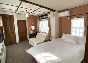 日光Shinkyo Inn的配有一张床和一把椅子的酒店客房