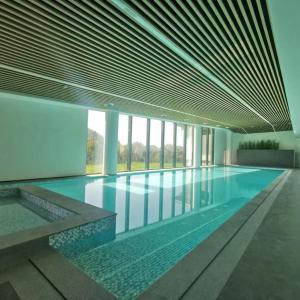永修吴城远洲酒店的一座大型游泳池,位于一座带窗户的建筑内