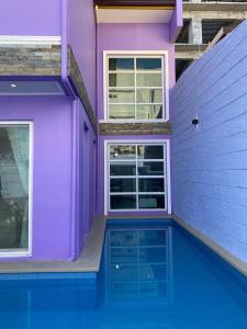Fort StotsenburgOn Pool Villa的一座紫色的房子,前面设有一个游泳池