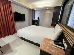台北承携行旅-台北信义馆(豪丽旺)的酒店客房,配有床和电视