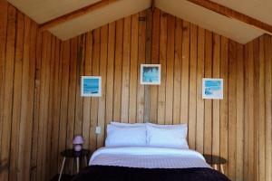 Bream CreekWaterfront 'Jemadda' Family Lodge的卧室配有木墙内的一张床