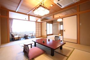 水上町辰巳馆酒店的客房设有桌椅和大窗户。