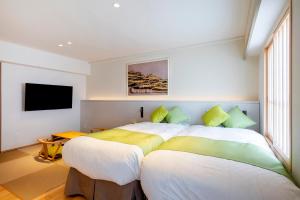 姬路克莱尔日笠酒店的一间卧室配有两张床和一台平面电视
