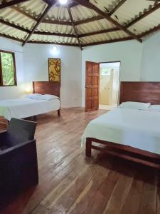 Isla Cebaco Isla Cébaco的一间卧室设有两张床,铺有木地板