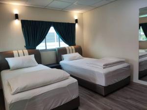 巴特沃思Zing Motel的酒店客房设有两张床和窗户。
