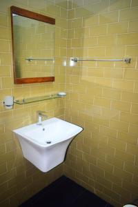 阿努拉德普勒Eleven11 Resort的黄色瓷砖浴室设有水槽和镜子
