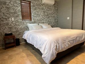 石垣岛HERO VILLA ocean suite的卧室配有带白色棉被的床