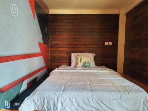珀尼达岛Tara hostel的一间小卧室,配有一张带木制床头板的床
