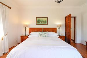 钓鱼镇托斯卡纳风格别墅旅馆的一间卧室配有一张带白色床单的大床