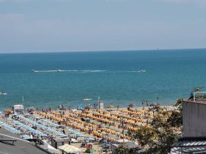 里米尼B&B Primrose Residence Hotel的海滩上放着一把遮阳伞,大海