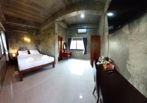 Khwaithai Resort & Homestay - ควายไทย的卧室配有一张床和一张桌子