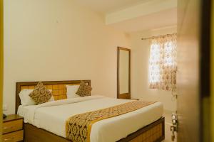 斋浦尔Hotel Cheelgadi的一间卧室设有一张大床和一个窗户。